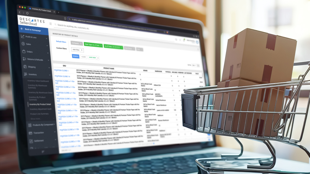 An image of a mini shopping cart resting on a laptop. The laptop screen shows a dashboard from Sellercloud.