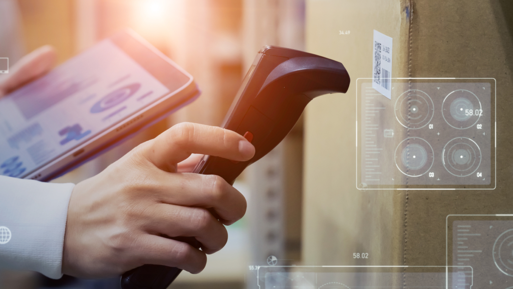 A warehouse worker holding a tablet in one hand scans a barcode with a scanner in the other.