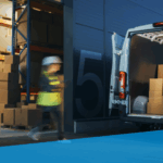 An image showing warehouse workers loading a vehicle outside a warehouse.