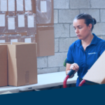 An image showing a warehouse worker moving order items around a warehouse.