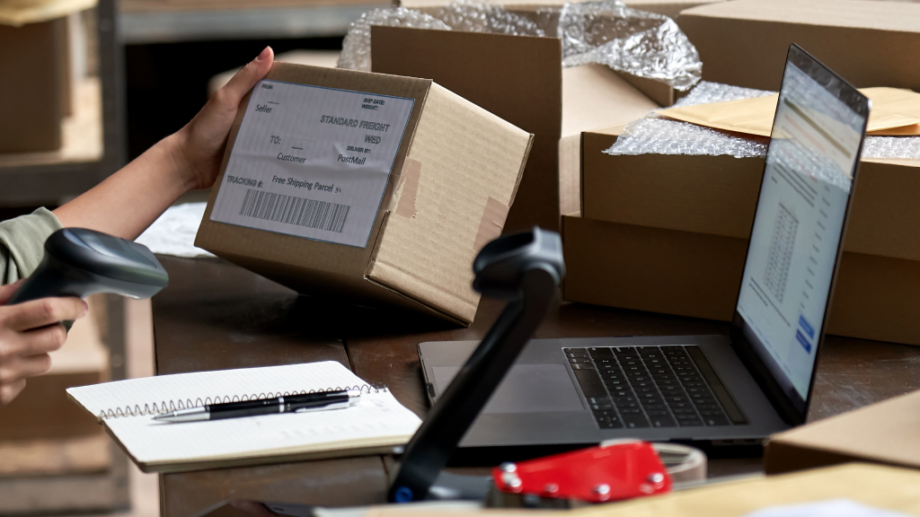 An image showing someone scanning an order in front of a laptop.