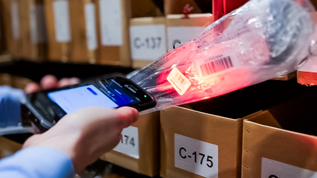 An image showing the Skustack app being used on a mobile device scanning a barcode in a warehouse. 