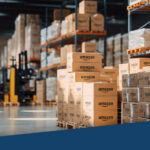 An image from inside a warehouse. To the right side, there are multiple boxes with 'Amazon' written on them.